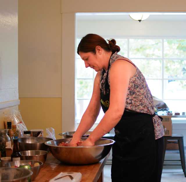 A cook preparing food by hand.