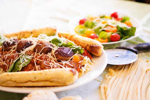 a plate of meatballs, garlic bread, and a side salad.