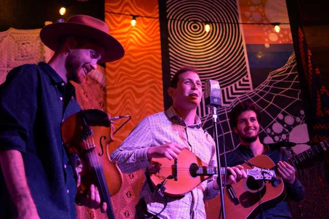 A band playing string instruments on stage.